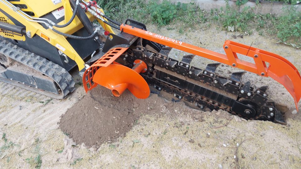 Implemento de zanjadora de cadena acoplado a una máquina compacta